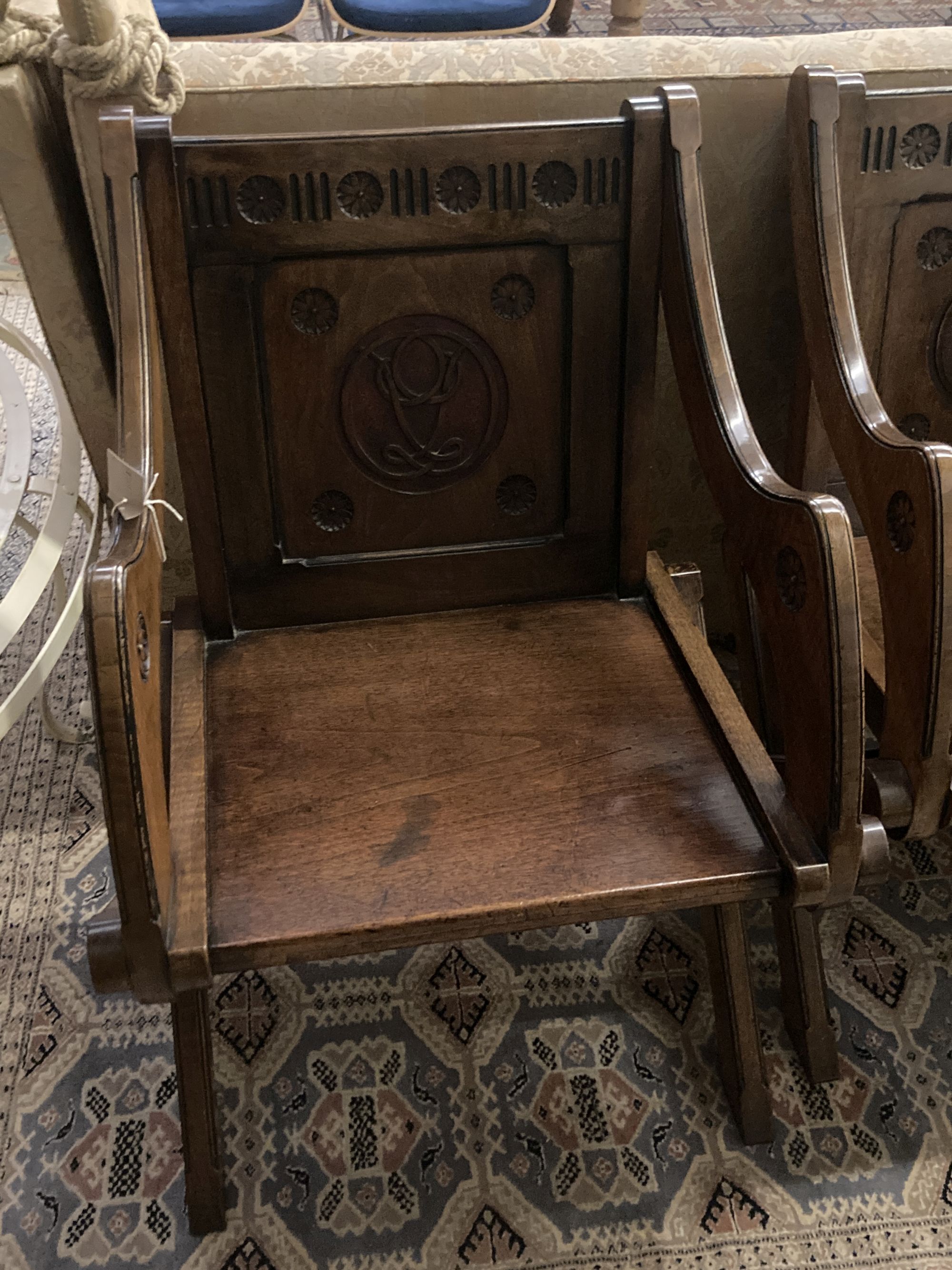 A pair of Glastonbury style walnut carved X frame chairs, width 64cm depth 48cm height 86cm